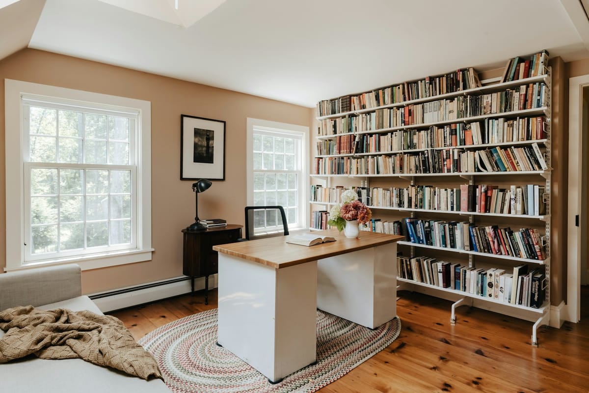 A room with a bed, desk and bookshelf